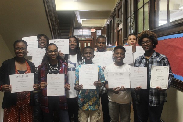 Eighth-grade students are proud to hold their honor roll certificates.
